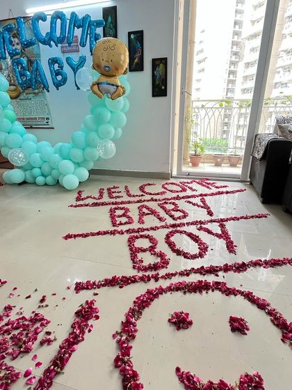 A simple and sweet welcome home decoration. I created a "WELCOME BABY BOY" message on the floor using rose petals, along with a small balloon arch in the corner. This is great for smaller spaces.