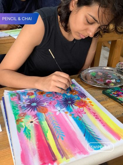 A student creates a vibrant, abstract floral piece. Our programs encourage personal expression, allowing each artist's unique style to shine through.