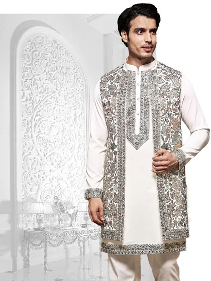 An artistic composition of our craftsmanship. This white kurta is layered with a heavily embroidered open jacket, showcasing a blend of traditional motifs and modern styling.