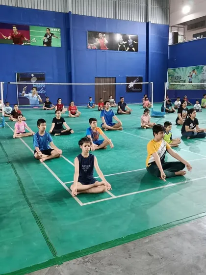 Our players in a seated meditation pose during a yoga session. This practice helps develop the mental concentration needed to stay focused during long and challenging matches.