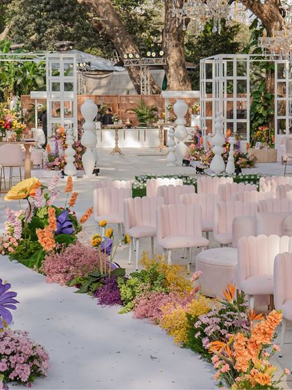 The guest seating area with modern pink scalloped chairs, all facing the spectacular floral stage.