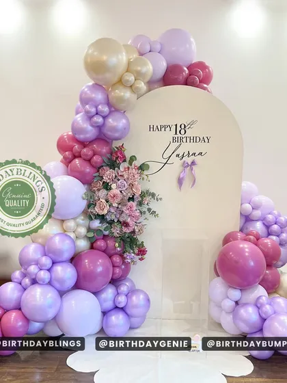 An elegant 18th birthday with a beautiful balloon arch in shades of purple and pink, accented with flowers. The "Genuine Quality" seal shows my commitment to high-end materials.