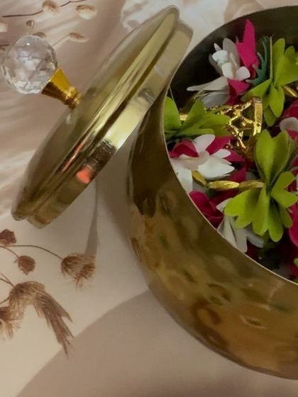 A peek inside the elegant metal handi, filled with colorful artificial flower torans or door hangings. These are a beautiful and reusable decor item for any festive occasion.