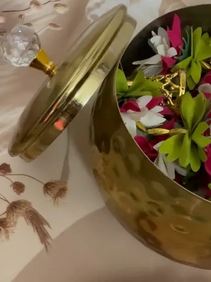 A peek inside the elegant metal handi, filled with colorful artificial flower torans or door hangings. These are a beautiful and reusable decor item for any festive occasion.