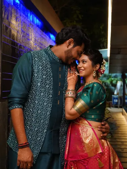 A tender moment between the couple, captured in a candid style during their evening engagement function.