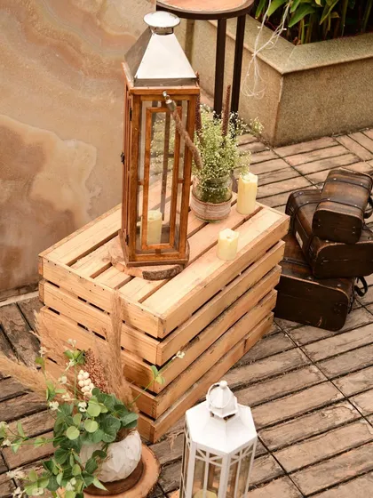 More details from the boho setup, including wooden trunks and lanterns that add to the rustic, traveled, and collected feel of the decor.