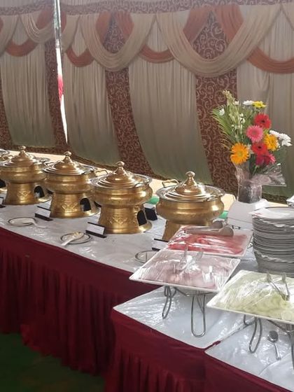 A classic buffet line ready for a large gathering. The long table is filled with our signature golden chafing dishes, ensuring every guest gets a hot and delicious meal.