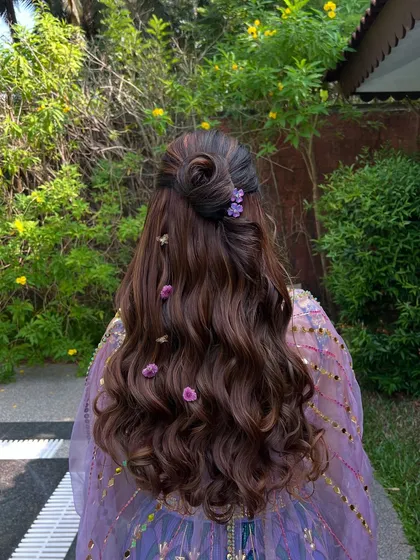 Another angle of the floral half-updo, showing the intricate details of the bun and the beautiful texture of the waves.