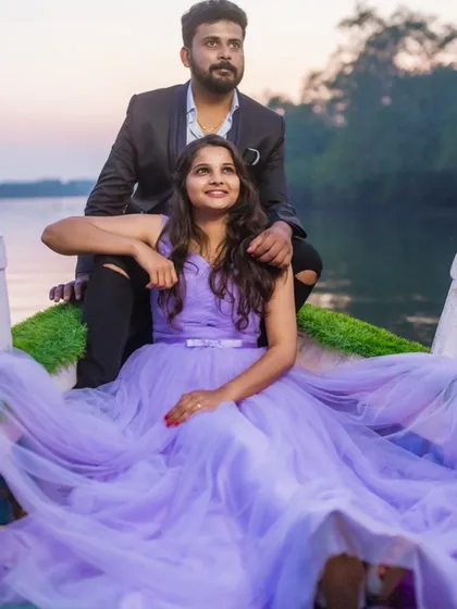 A dreamy pre-wedding shoot on a boat. The soft lavender tulle of this gown spreads out around the couple, creating a romantic and serene atmosphere on the water at sunset.