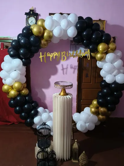 This black, white, and gold balloon ring is a versatile and stylish option for birthdays. The single pedestal in the center is perfect for showcasing a birthday cake.