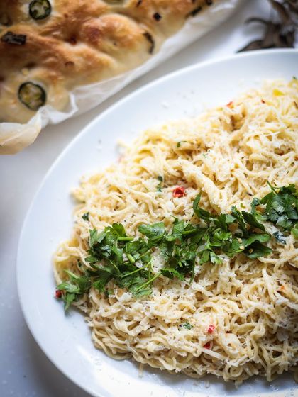 Aglio e olio, a simple yet elegant pasta dish, served alongside freshly baked focaccia bread.