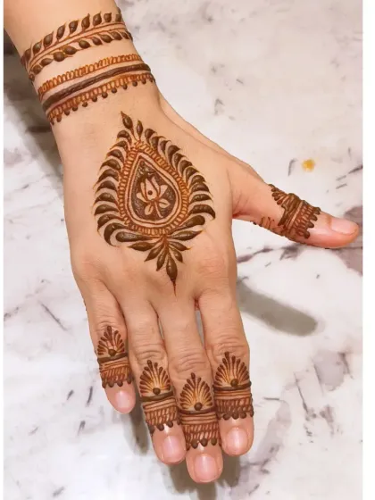 Minimalism can be incredibly striking. This design is perfect for a wedding guest, featuring a central paisley motif with delicate finger and wrist details. It's a quick, modern, and elegant option that still feels special.