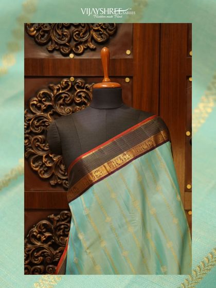 A serene light blue Kanjivaram with a contrasting dark border, a calm and graceful option for pujas.