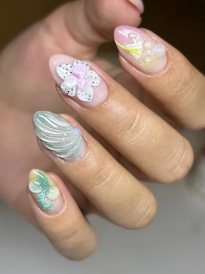A close-up of the delicate, hand-sculpted 3D elements in this summer-themed set, including a flower with dotted details and a textured shell.