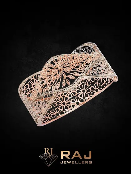 A wide cuff bracelet with intricate, laser-cut floral and geometric patterns. This statement piece showcases exceptional craftsmanship and is designed to be a conversation starter.