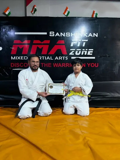 This student is all smiles after being awarded his yellow belt and certificate, marking his official start in the world of karate.