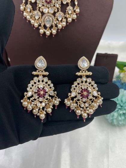 The beautiful chandbali-style earrings from our Ziva and Darbaar necklace sets. These earrings are adorned with pearls and colored stones, making them a popular choice.