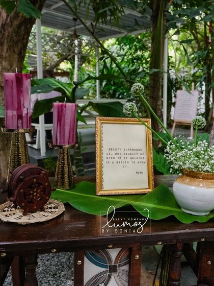A detail shot from the personalized corner, featuring a framed quote, candles, and a banana leaf, blending modern and traditional aesthetics.