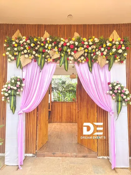 The entrance sets the tone for your entire event. I create beautiful, welcoming doorways using fresh flowers and fabrics, like this traditional yet stylish arrangement perfect for a housewarming, engagement, or festive celebration in Bengaluru.