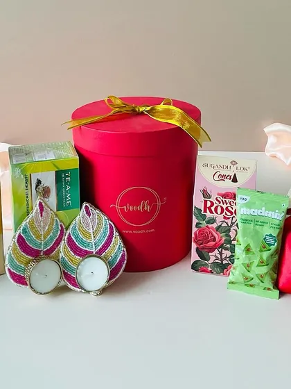 A slightly different angle of the round red box hamper, showing all the delightful items included for a complete festive gift.