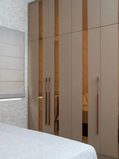 A detailed shot of the wardrobe, showing how the reflective surfaces and clean lines contribute to the room's wonderfully elegant feel.