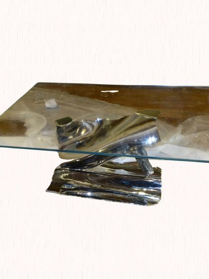 This glass-topped coffee table with a crumpled steel base was designed 15 years ago, but its modern, timeless design still feels relevant today.