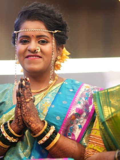 That special mehendi glow. This happy bride is all smiles during her wedding ceremony, with her beautifully stained hands in a traditional namaste pose.