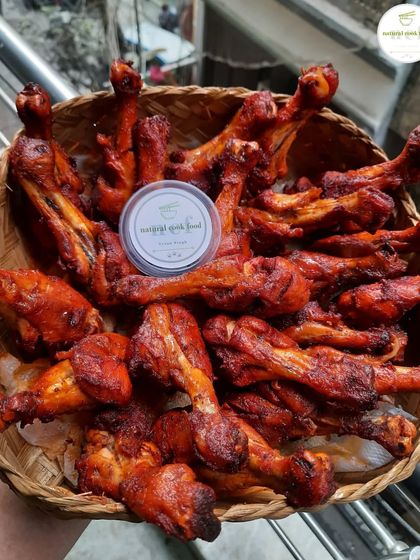 A basket of freshly fried chicken drumsticks, crispy and ready to eat.