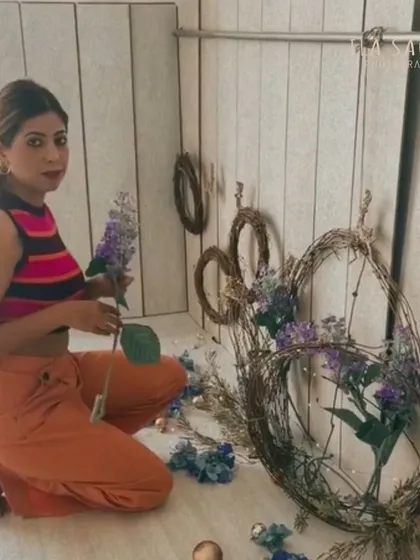 I often create my own custom backdrops. Here, I am arranging grapevine wreaths with artificial lavender for a unique, rustic set. These wreaths are part of the collection I'm selling.