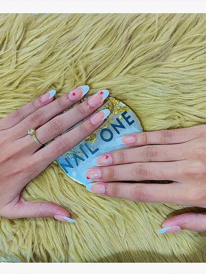 A simple and sweet design featuring a modified French tip in a soft blue, accented with a tiny red heart. This look is perfect for those who appreciate minimalist art with a touch of color.