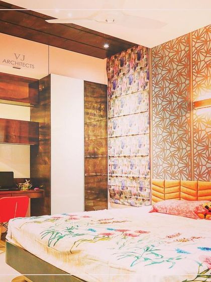 This vibrant bedroom is designed for a younger client, featuring a colorful patterned headboard and a geometric CNC-cut wall panel. The built-in desk and shelving create a functional study nook.