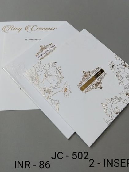 A beautiful white invitation with gold foil floral line art and a simple nameplate. The design is clean, modern, and effortlessly chic.