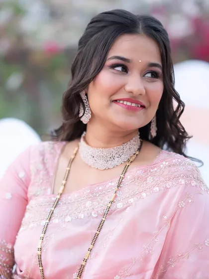 A close-up of her reception makeup, featuring a soft pink lip and shimmery eyes that sparkle in the light.