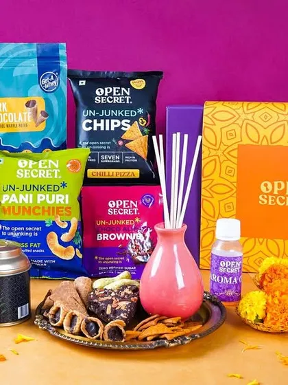 A colorful assortment of Open Secret's Diwali gift products, including chips, nuts, and teas. The vibrant background and festive props create an energetic and appealing product lineup.