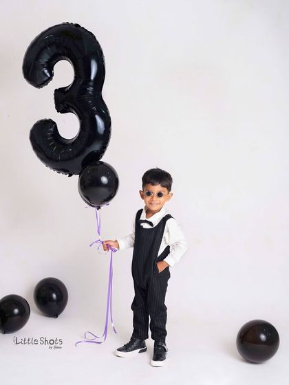 A cool and stylish third birthday portrait with dad. The little boy's playful pose, covering his dad's eye, shows their fun and loving relationship.
