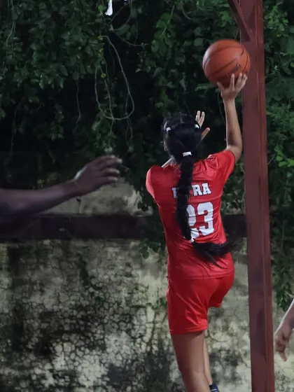 A female player practices her shooting form, aiming for the perfect release. We are committed to developing all players, helping them reach their potential.