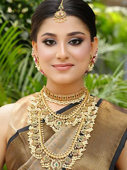 A beautiful outdoor shot that captures the golden glow of her skin and the intricate details of her temple jewelry.