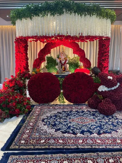 For an intimate home celebration, we designed this stunning floral mandap using thousands of red roses. The mirrored floor adds a touch of glamour, reflecting the vibrant decor and creating a truly immersive worship space.