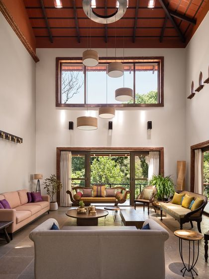 The formal living room at the Dream Coffee Estate is a double-height space that breathes with the surrounding nature. I used a mix of new and upcycled antique furniture, hand-chiseled stone flooring, and a palette of muted tones to create a sanctuary of quiet, understated elegance.