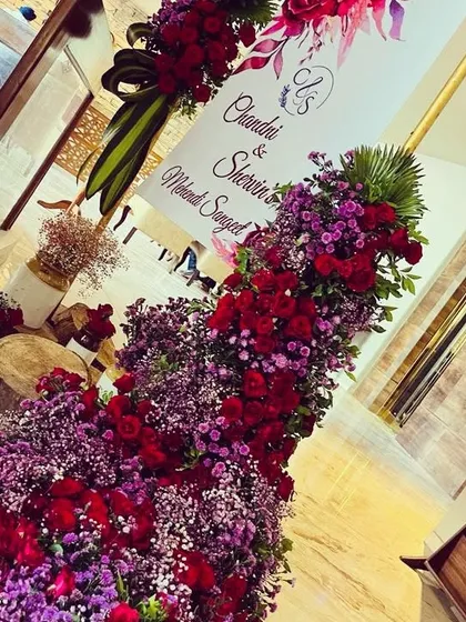 A luxurious welcome arrangement for Chandni and Sherwin's Mehendi Sangeet. A cascade of red roses and purple filler flowers creates a rich and dramatic statement at the entrance.