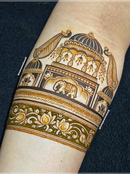 A stunning bridal arm band in progress. This section features a grand palace entrance with an elephant, decorated with jhumkas and peacock feathers.