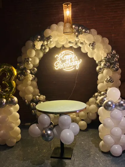 Here’s a chic and modern setup perfect for any adult celebration. This design features a full balloon arch in a classy white and chrome silver palette, a stylish cake table, and a custom neon "Happy Birthday" sign that glows for the perfect party vibe.
