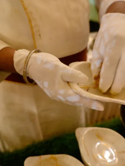 With gloved hands, our chef carefully assembles a dish. This demonstrates our commitment to hygiene and the detailed craftsmanship that goes into every single serving.