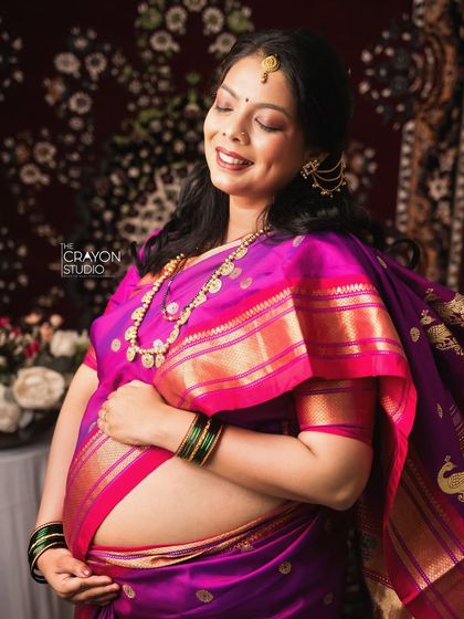 The pure joy of pregnancy shines through in this beautiful solo portrait. Her radiant smile and the traditional attire make this a cherished memory of her glow.