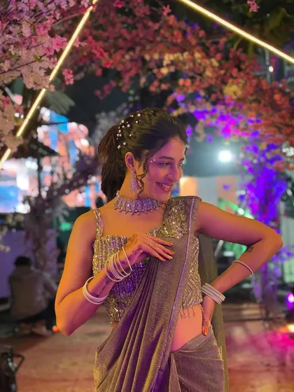 This client is enjoying her event, looking stylish and feeling comfortable in the green shimmer pre-draped saree. Renting means you can wear a dazzling outfit like this for one night.