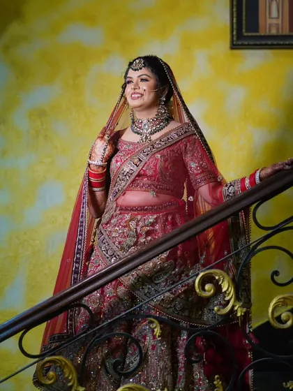 A classic portrait on the stairs, allowing the bride's lehenga to be displayed fully. The elegant setting complements her graceful pose.