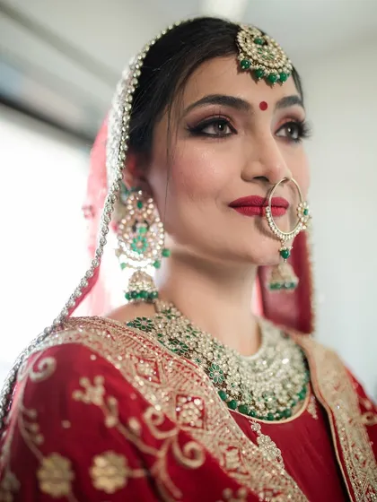 A stunning close-up of this Punjabi bride. The classic red lip, winged eyeliner, and the traditional nath create a timeless and beautiful look.
