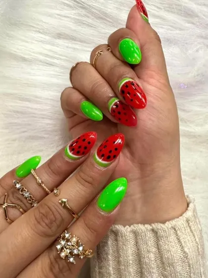 A fun and fruity summer design. These watermelon-inspired nails feature bright green and red with hand-painted seeds, perfect for a vacation.