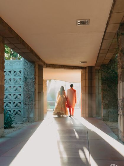 A beautiful shot of the couple walking into the light. The strong architectural lines and the golden sunlight create a hopeful and artistic image of them stepping into their future together.