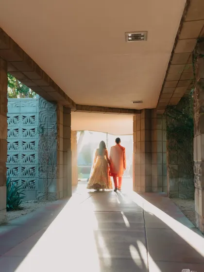 A beautiful shot of the couple walking into the light. The strong architectural lines and the golden sunlight create a hopeful and artistic image of them stepping into their future together.